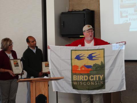 Carl Schwartz presents the flags to Madison and Maple Bluff.