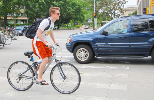 A cyclist rides near traffic in Madison (Xin Wang/Madison Commons)