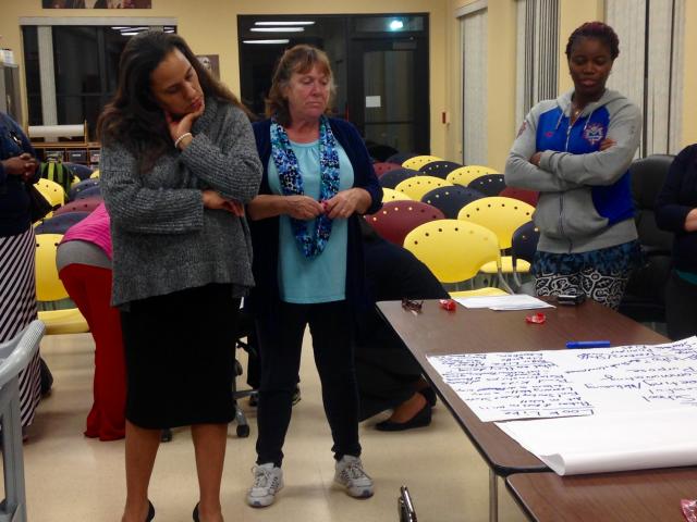 Chela O’Connor, the district’s full service school planner, looks over what community members wrote would be characteristics of an ideal community school as part of a brainstorming activity at the listening session Wednesday, Oct. 21.: (Abby Becker/Madison Commons)