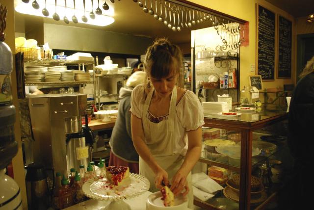 Christa Parmentier, baker at Sophia's Bakery and Cafe cuts slices of cherry cheesecake.