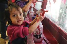 Yarecsy plays with window paint at the Madison Children's Museum during Day in a Kid's Life (Kait Vosswinkel/Madison Commons).