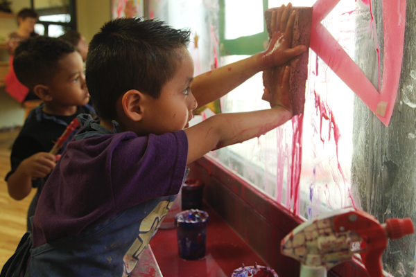 Oliver plays with a sponge on a paint window at the Madison Children's Museum during Day in a Kid's Life, an event aimed at documenting first-person perspectives of childhood (Kait Vosswinkel/Madison Commons)