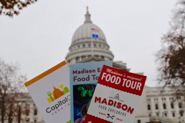 Food tour brochures in front of the Wisconsin State Capitol. Each company provides their own unique downtown food tour (Daniella Byck/Madison Commons).