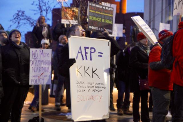 A protester from the Madison community laughs at a speaker’s joke. (Melissa Behling/Madison Commons)