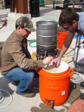 Johnson (right) walks Austin (left) through the beer brewing process.