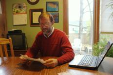 Mark Bauman looks over comments on the petition to stop the removal of his trees.