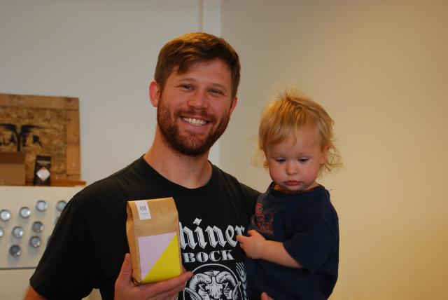 Kyle Johnson, seen with his daughter Etta, holds a bag of Kin-Kin’s Guatemala coffee. The new specialty coffee is available at Johnson Public House and the planned coffee shop, A-OK (Aparna Vidyasagar/Madison Commons).
