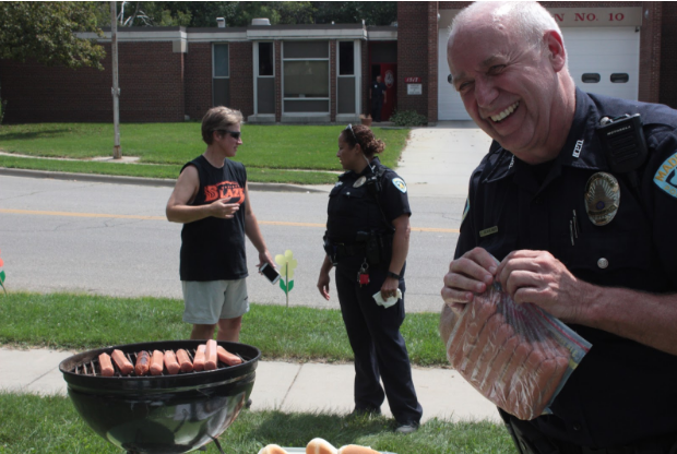 Officer Dexheimer manages the grill while Officer Reyes chats with community members. (Kate Jungers/Madison Commons)