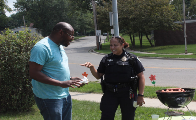 Omoregie Igiehon, a tenant of the apartment complex nearby, chats with Officer Reyes. (Kate Jungers/Madison Commons)