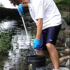 Josh Weber fishes trash out of Monona Bay.