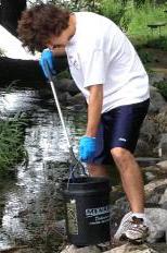 Josh Weber fishes trash out of Monona Bay.