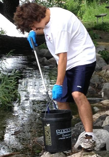 Josh Weber fishes trash out of Monona Bay.