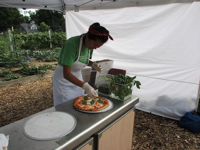 AfIda Yu applies the finishing touches to a pizza. Yu completed the Beginning Farmers Training program at Troy Farm, became an intern, and still participates as a worker share in exchange for a CSA membership. (Logan Garcia/Madiso