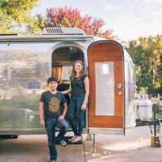 Maria and En Tao Ko pose with a trailer they seek Kickstarter help to purchase. They want to use it to expand their photography business and forge connections between communities.