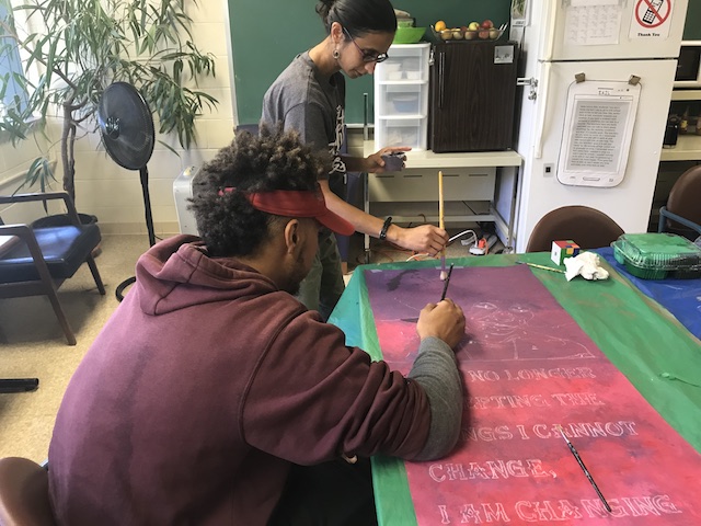 West High School SAIL student Jayden Burcham paints a banner intended for Hoyt School's hallway (Erin Green/Madison Commons).