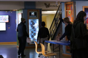 Staff directs guardian and child toward the children's vaccine clinic.