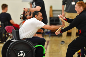 Fencil teaching taekwondo to athletes with disabilities.