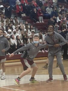 Camron Yahnke boxing out coach Curtel Robinson during basketball warmups