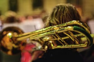 Over the shoulder shot of a young trombone player with their instruments