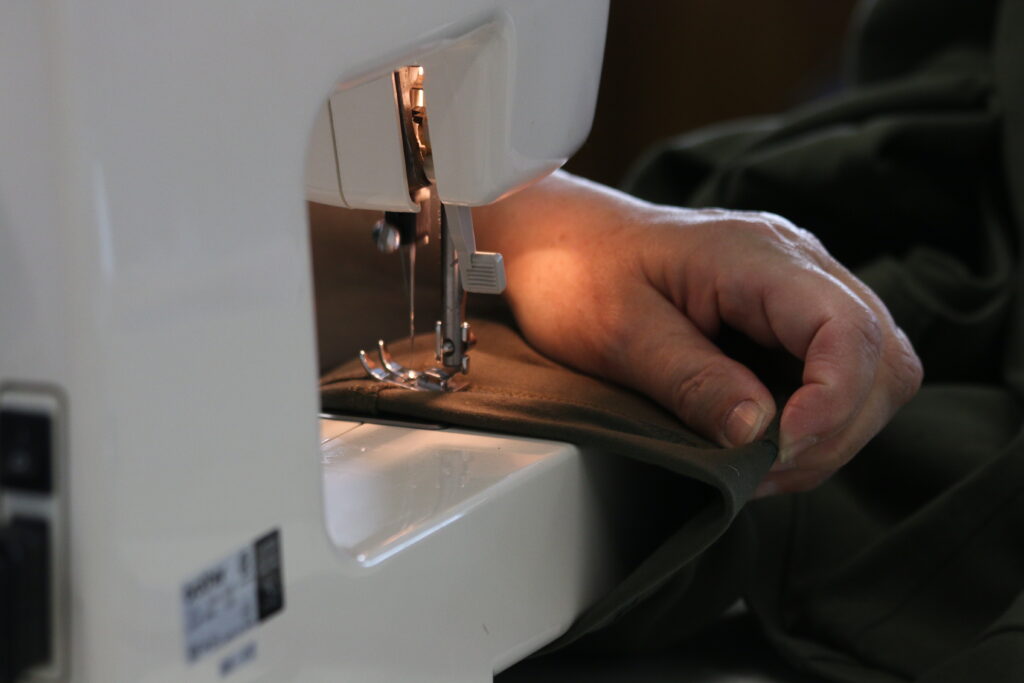 Wendy Schneider mending garments with precision and skill using the sewing machine during a winter session at Madison’s Central Library.
