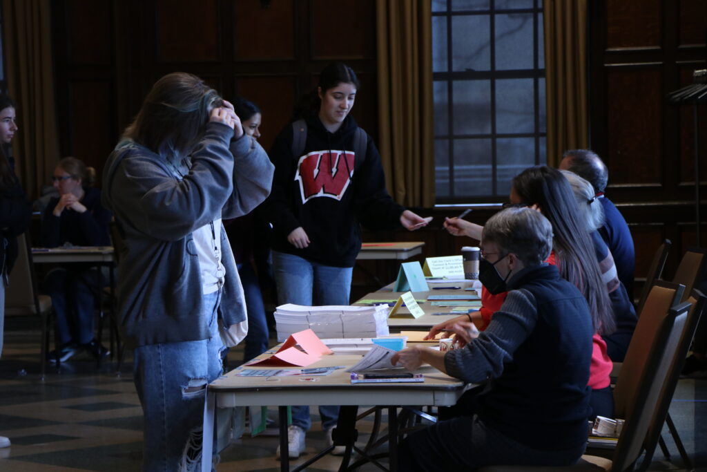 University of Wisconsin-Madison students receive their ballots from poll workers in the Memorial Union on April 4, 2023.