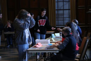University of Wisconsin-Madison students receive their ballots from poll workers in the Memorial Union.