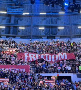 Audience members hold a large banner that reads "Freedom". 