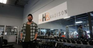 Josh Kosier stands proudly in the middle of The HQ Madison weight room