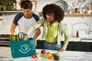 Two shoppers opening a bag of food from Too Good to Go