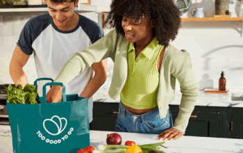 Two shoppers opening a bag of food from Too Good to Go