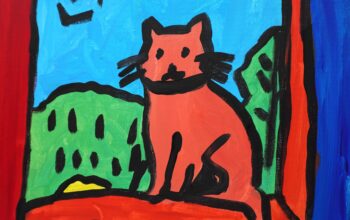 Red cat on a red window sill with a nice day outside