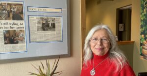 Photo of hairdresser Betsy Thibedeau wearing a red sweater.