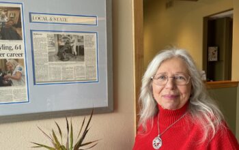 Photo of hairdresser Betsy Thibedeau wearing a red sweater.