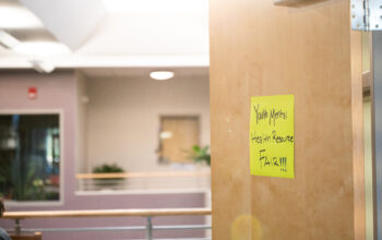 A yellow sign on a brown door reads "Youth Mental Health Fair"