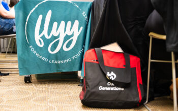 A blue sign that says FLYY and a black bag