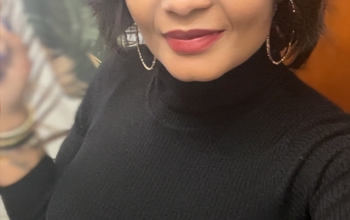 A Black woman wears a black shirt as she takes a selfie
