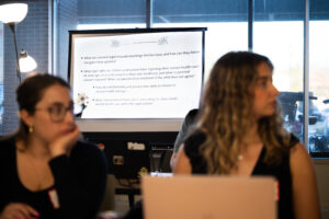 A slide giving some legal rights information is between two white women who are presenting.